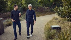 Two men in dark clothing walk down walk in outdoor park