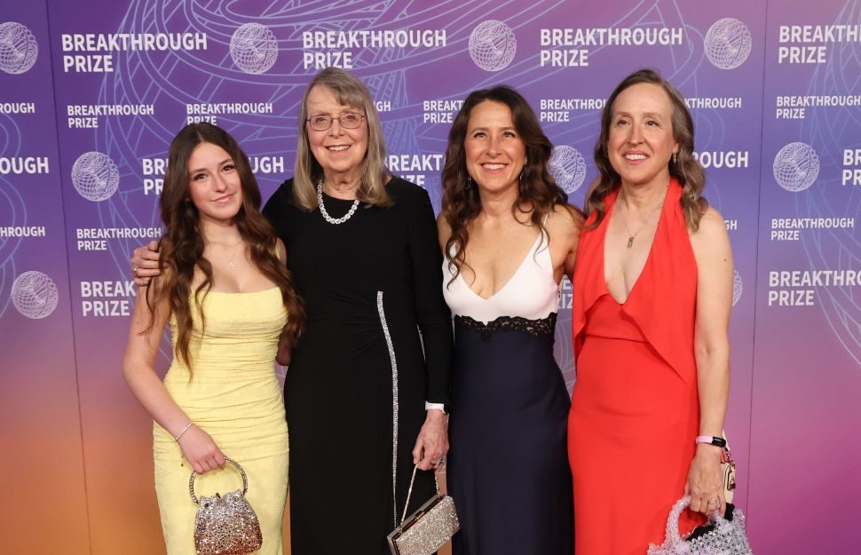 Four women in evening gowns posing for a photo.