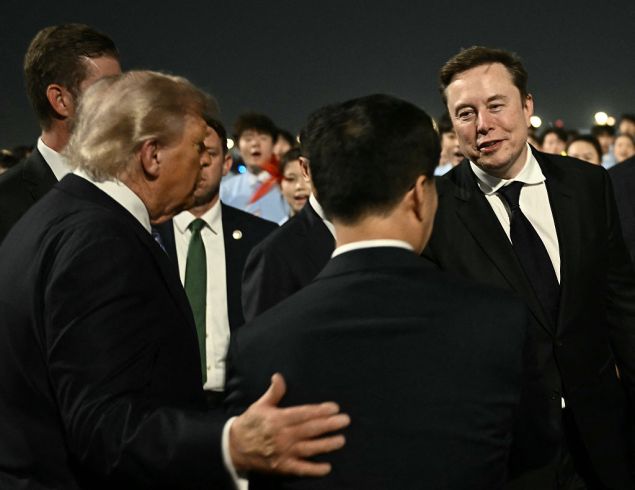 US President Donald Trump (C) presents SpaceX, Twitter and electric car maker Tesla CEO Elon Musk (R) to China's Vice President Han Zheng at Beijing Capital Airport in Beijing on May 13, 2026.