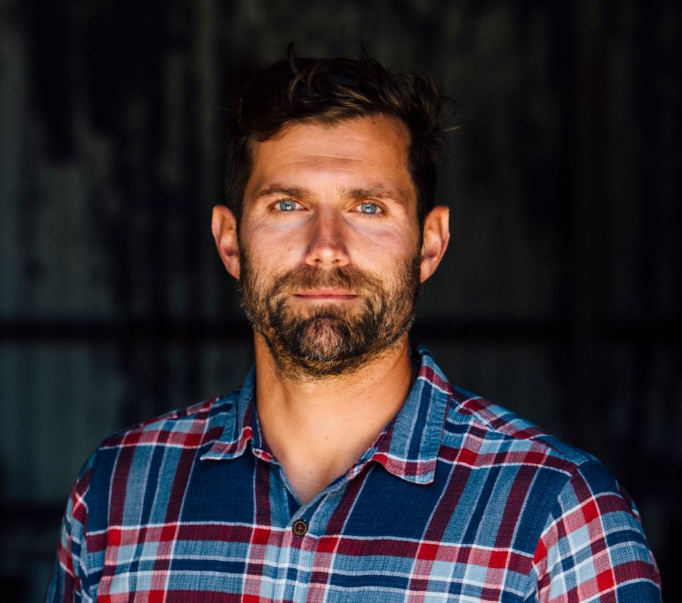 Headshot of man in plaid flannel shirt.