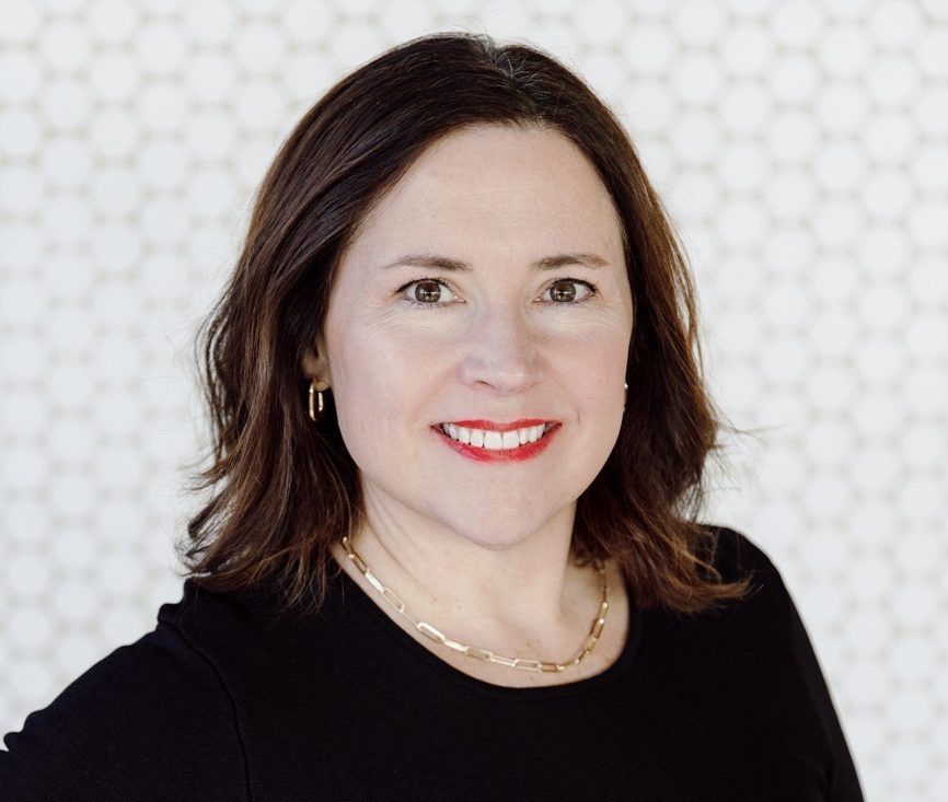 A woman in a black sweater posing for a headshot