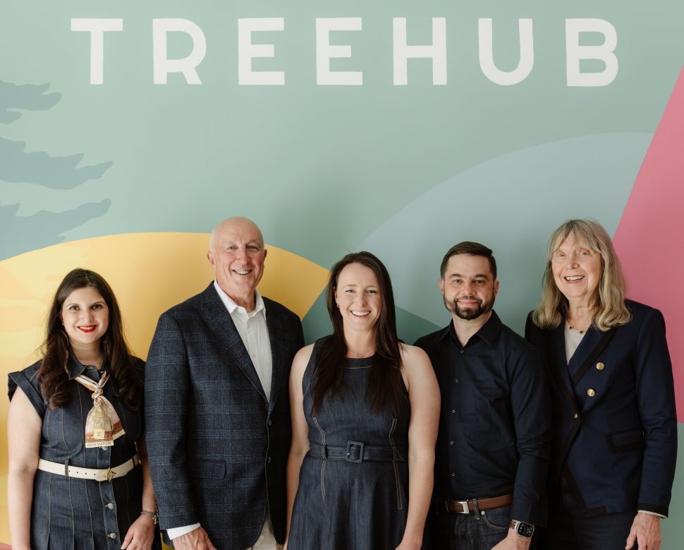 Five people (three women and two men) stand in front of wall reading 'Treehub'